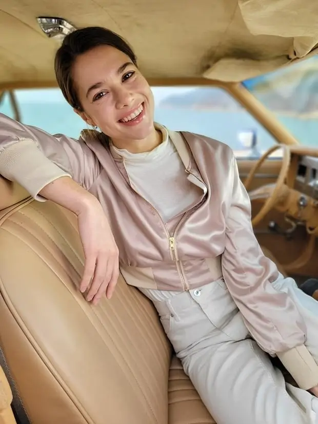 The same portrait with the car and sea blurred behind her