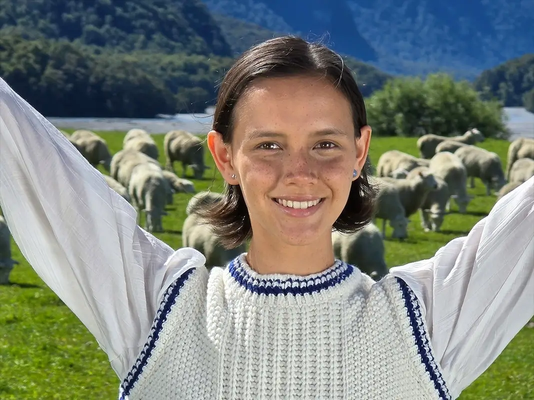 At 10x: a close portrait of one young woman smiling, the field soft behind her