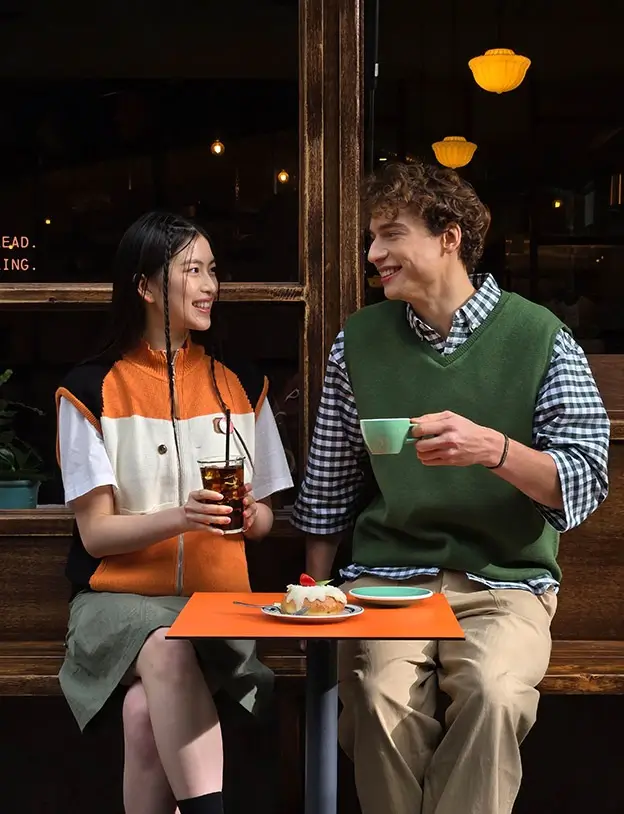 Closer still: the two friends fill the frame, a slice of cake on the table between them