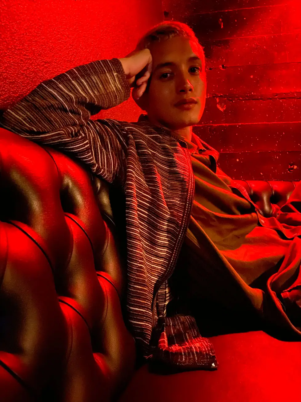 The same photo with Night mode: the person, the striped shirt and the red room are bright and clear