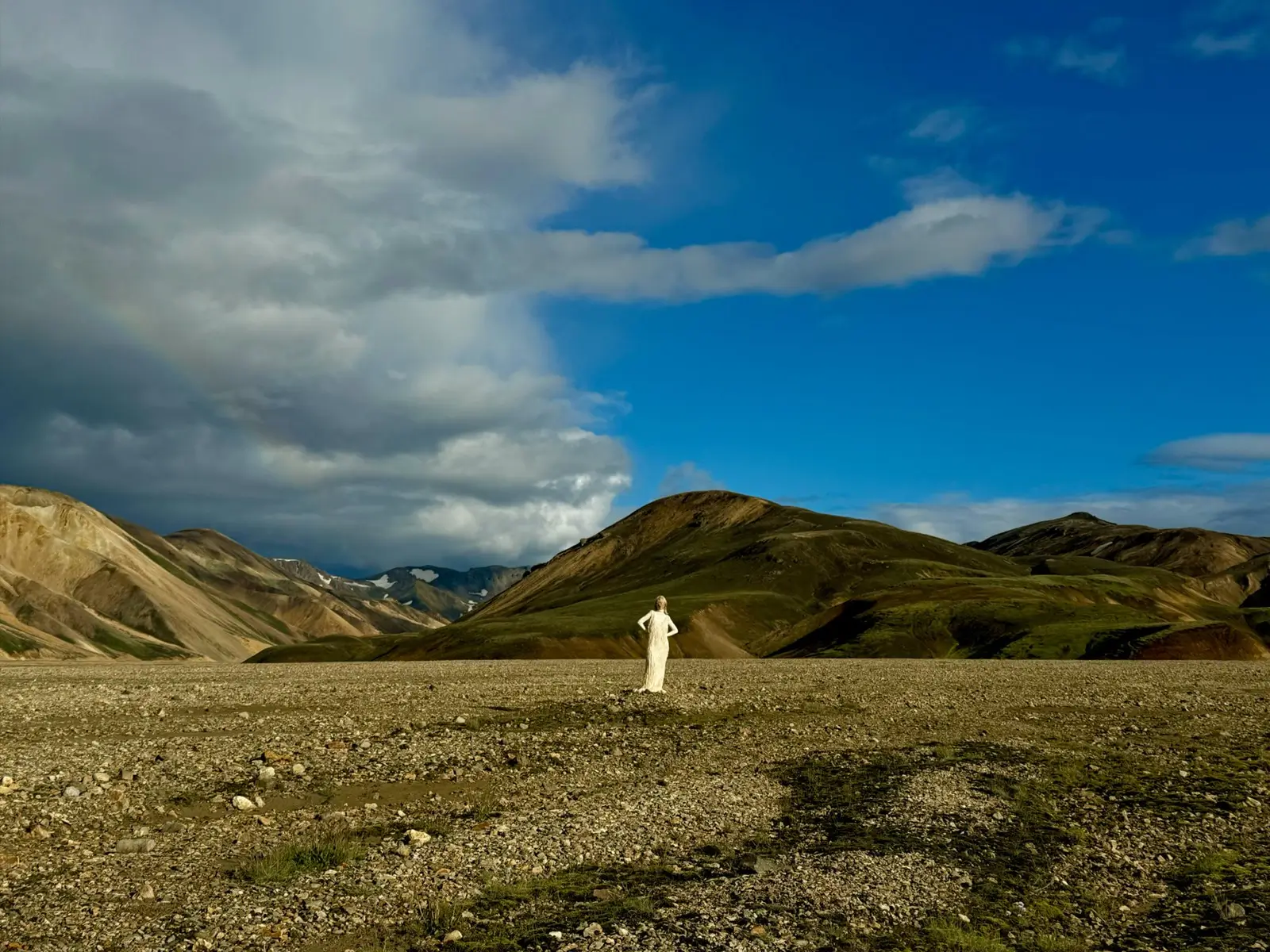 At 35 mm the green hill behind the person in white fills the middle of the frame