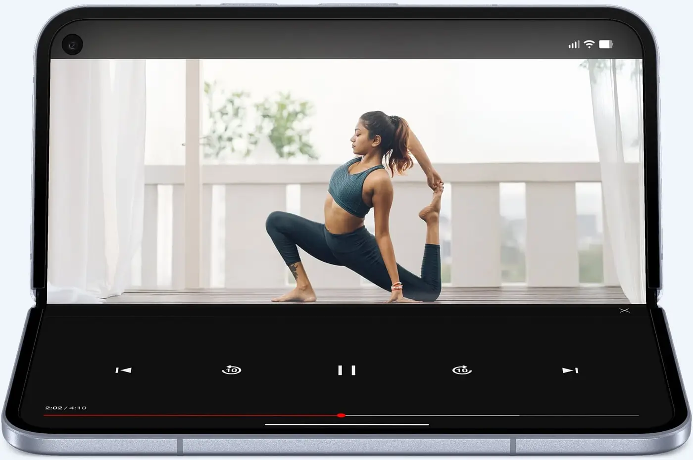 A Pixel 10 Pro Fold propped half open, a yoga video on the top half and playback controls below