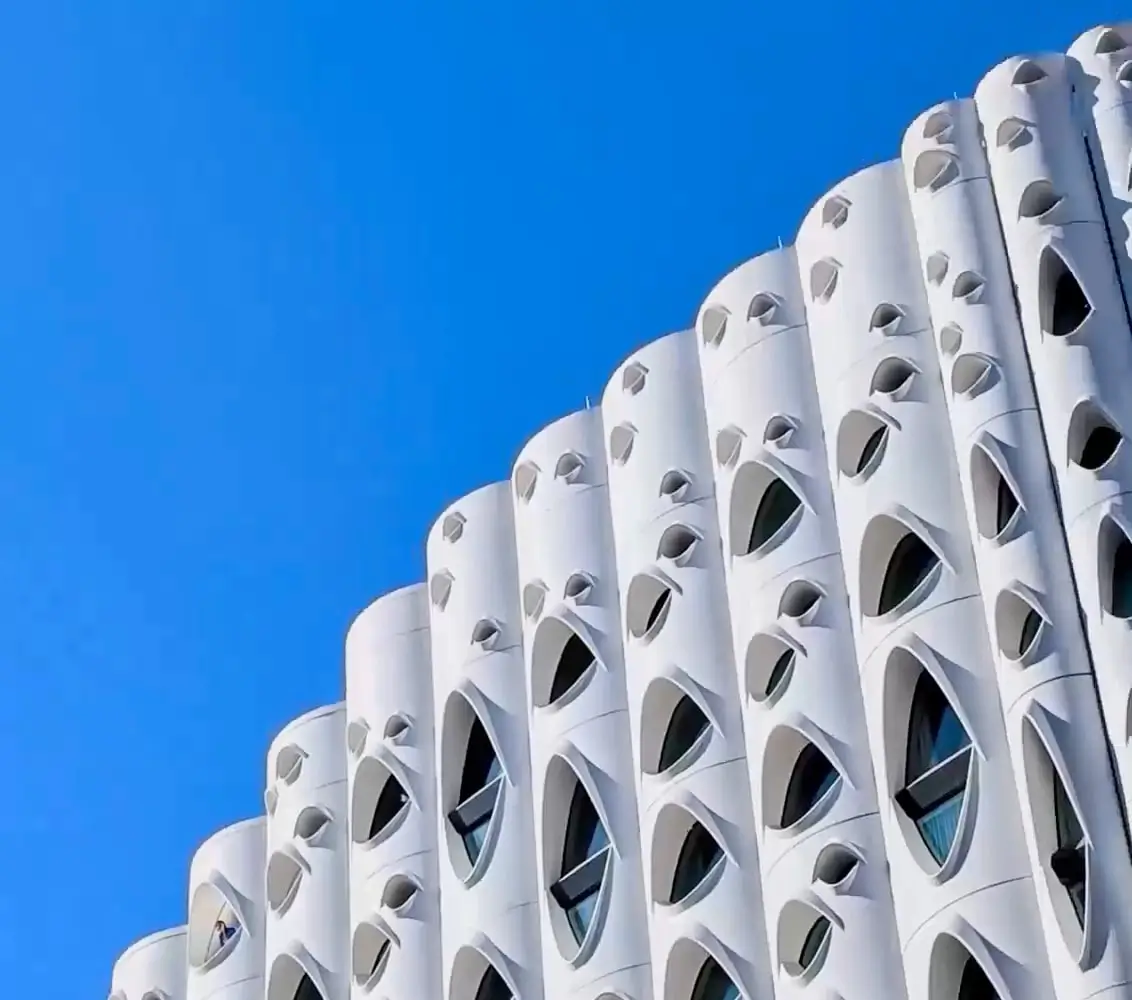 At 2x: rows of the building's curved windows climbing towards the sky