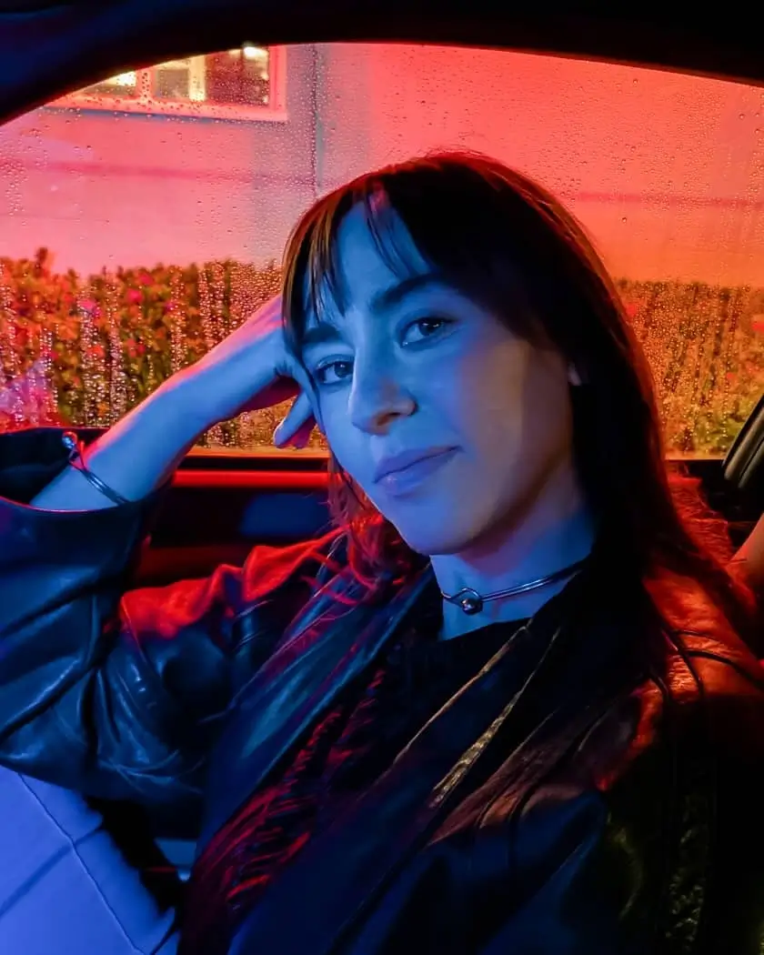 Night Sight: a woman sitting in a car at night, her face clear against red and blue light