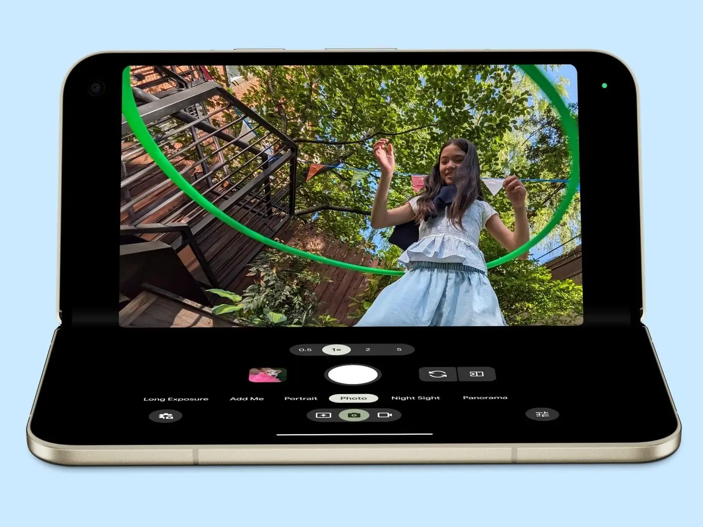 A Pixel 11 Pro Fold half open in tabletop mode takes a photo of a woman waving on a staircase among trees