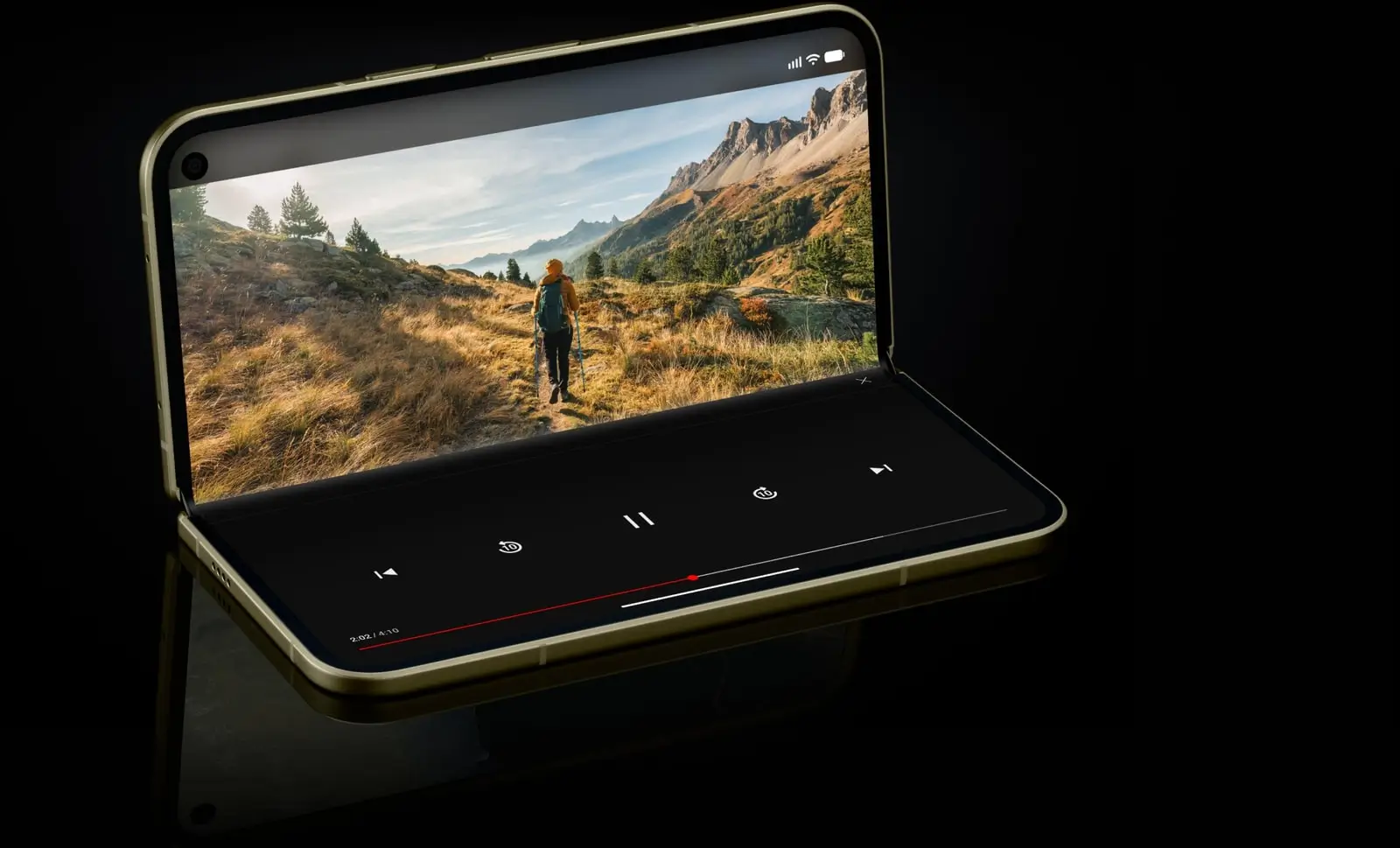 A Pixel 11 Pro Fold propped half open in tabletop mode, a hiking video on the upper half and playback controls on the lower half