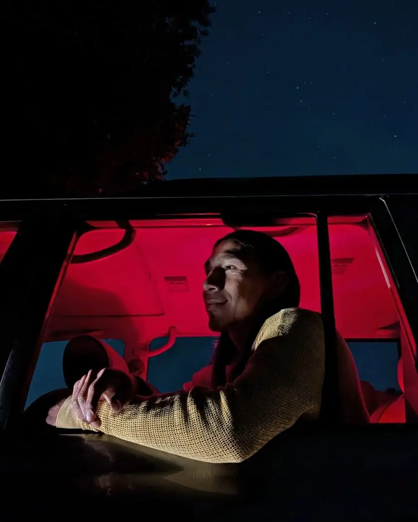 Night Sight: a person sits in a car at night, the interior glowing red